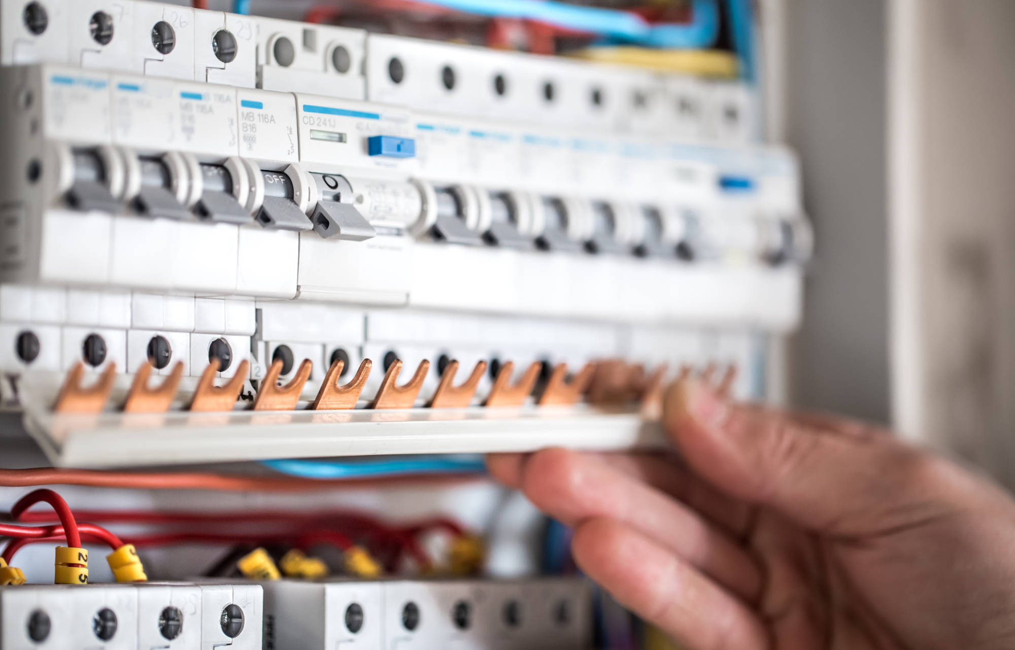man-electrical-technician-working-switchboard-with-fuses-installation-connection-electrical-equipment-close-up.jpg